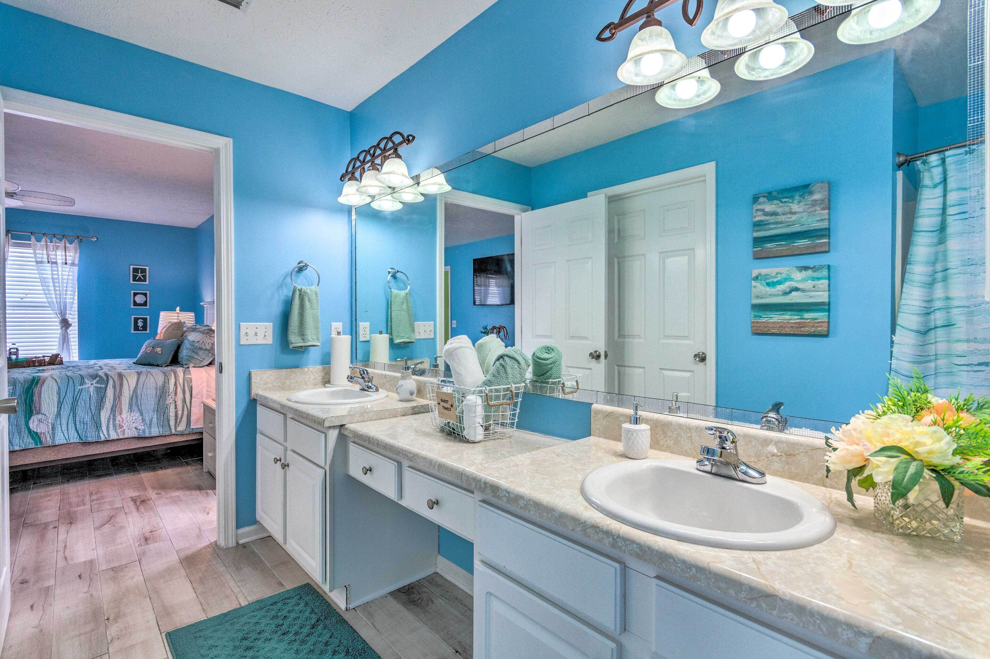 A bathroom with two sinks, a large mirror, and a shower curtain.