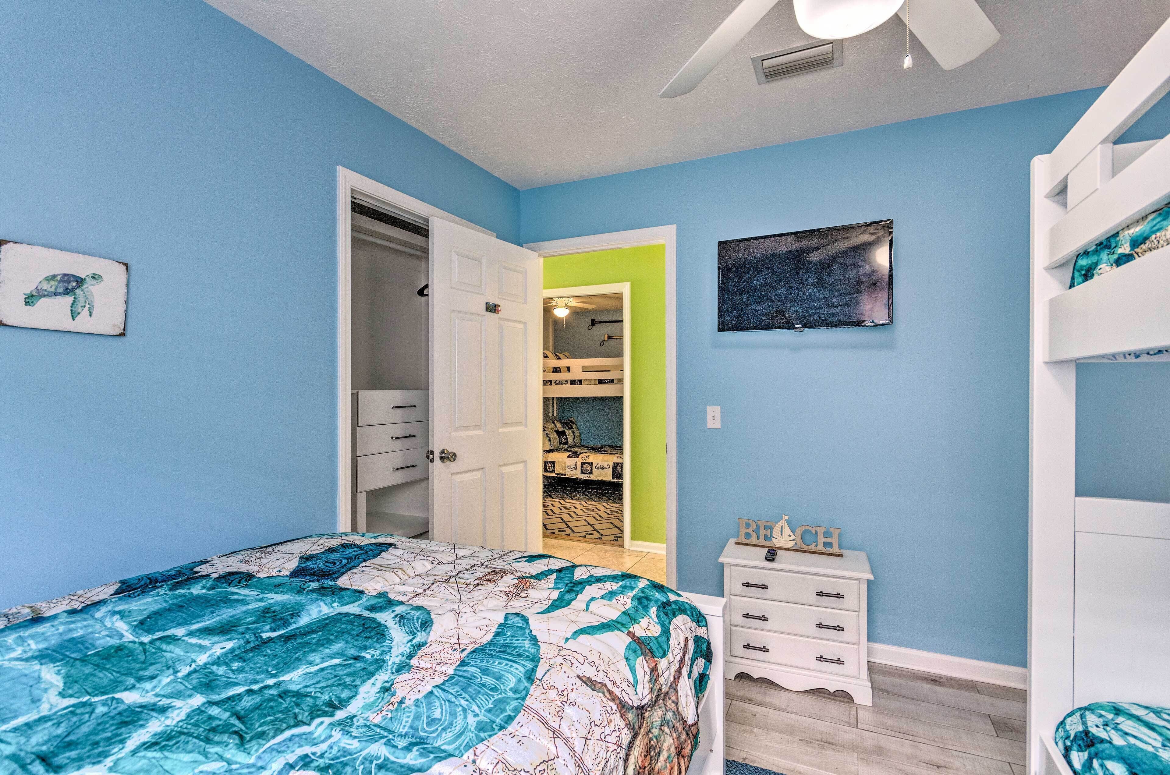 A bedroom with a bed, a dresser, a closet, and a bunk bed.
