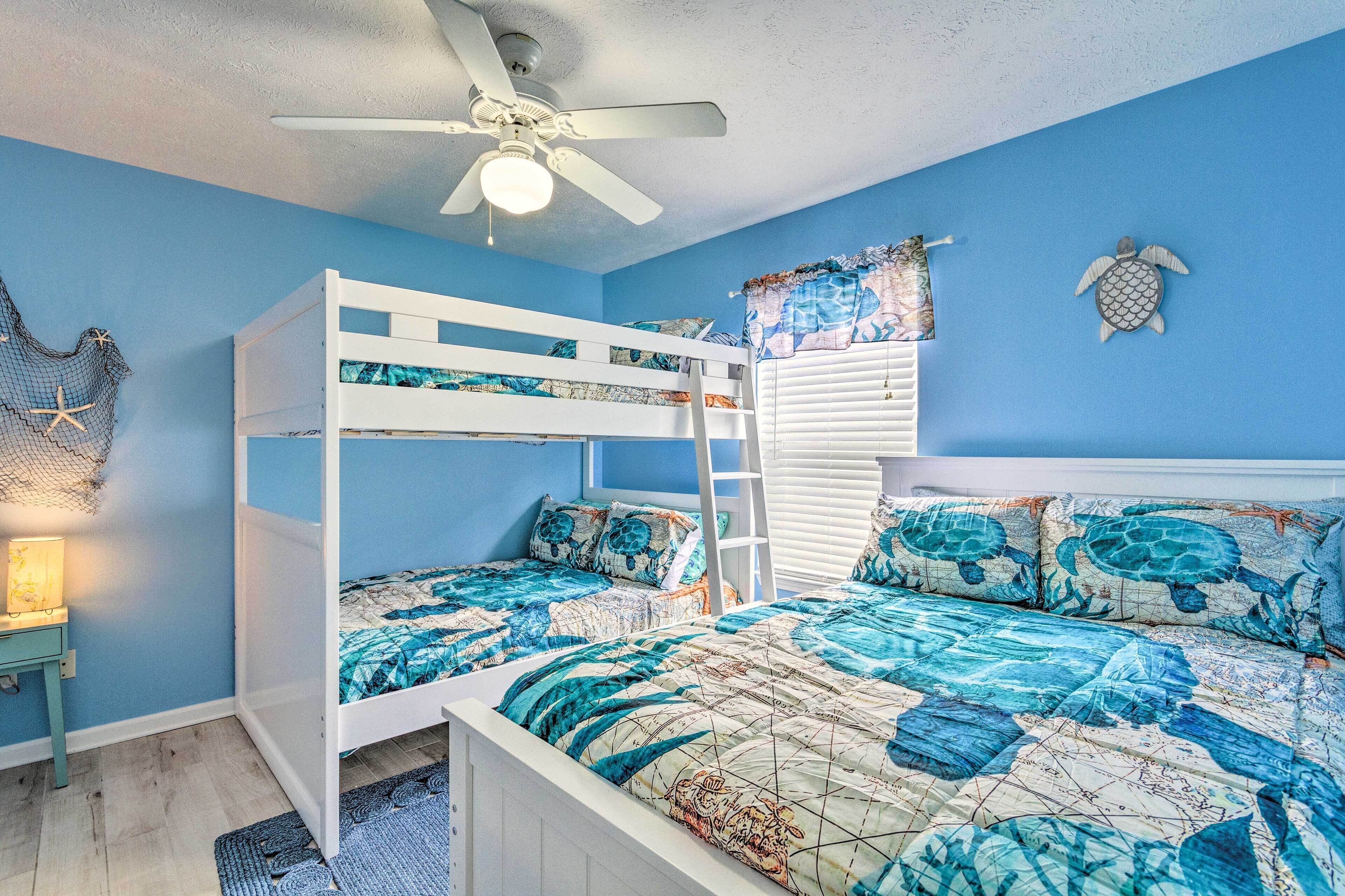 Une chambre avec un lit superposé, un ventilateur de plafond et une décoration représentant une tortue au mur.