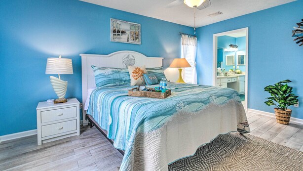 A bedroom with a bed, nightstand, lamp, ceiling fan, and a potted plant. - PCB Retreat w/ Patio & Grill < 1 Mi to Beach! (Panama City Beach)