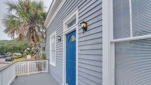 A house with a blue door, white railings, and two wall-mounted lights. - 4 Blocks to Beach! Family-friendly Galveston Home (Galveston)