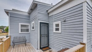 A house with a wooden deck, a black metal bench, and a grey door. - 4 Blocks to Beach! Family-friendly Galveston Home (Galveston)