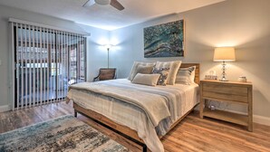 A bedroom with a bed, bedside table, lamp, and a painting on the wall. - Outdoor Retreat in Edgewater w/ Private Pool (Edgewater)