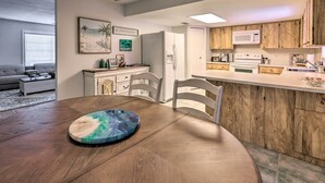 A modern kitchen with wooden cabinets, a white refrigerator, and a microwave. - Outdoor Retreat in Edgewater w/ Private Pool (Edgewater)