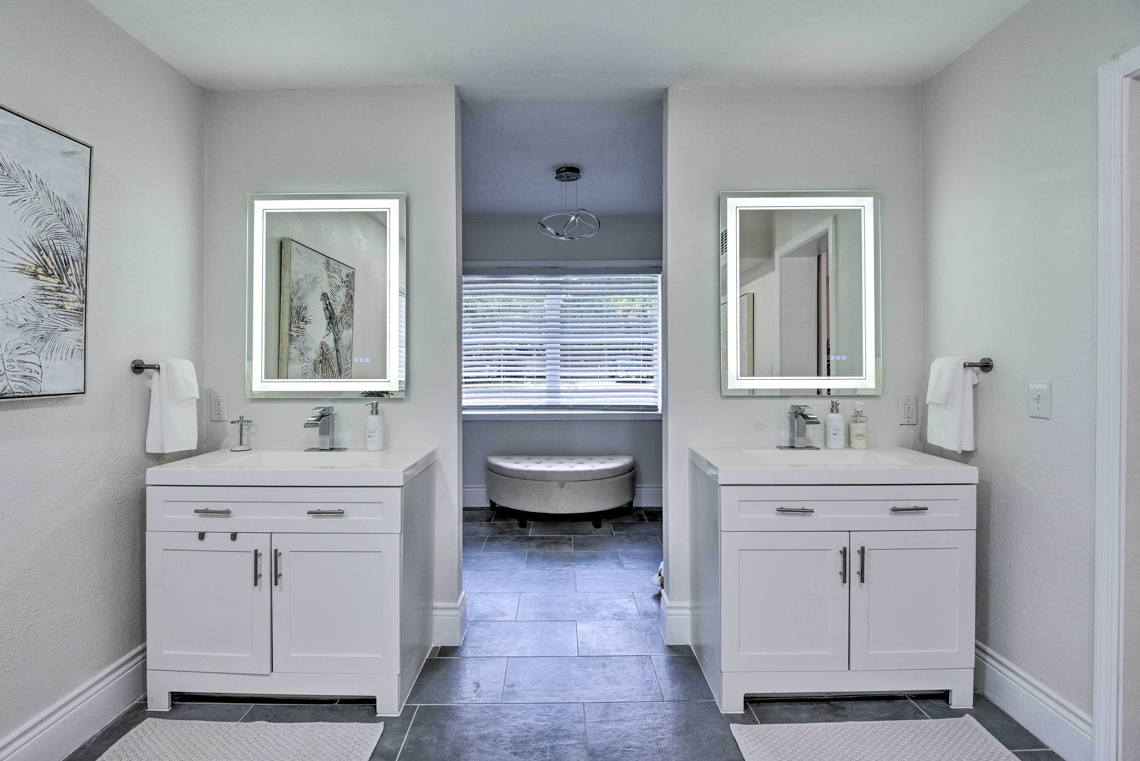 A modern bathroom with two sinks, a vanity, and a toilet.
