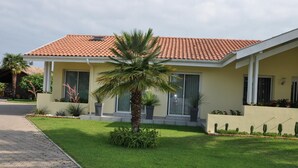 A two-story house with a tiled roof, a front porch, and a well-maintained lawn. - Chalet Simone - ST-VINCENT-DE-TYROSSE (ST-VINCENT-DE-TYROSSE)