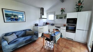 A compact living space with a kitchenette, a dining area, and a sofa. - Chalet Simone - ST-VINCENT-DE-TYROSSE (ST-VINCENT-DE-TYROSSE)