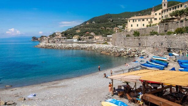 A coastal town with a beach, boats, and a historic building with a bell tower. - Cherry Tree House-Affitti Brevi Italia (Recco)