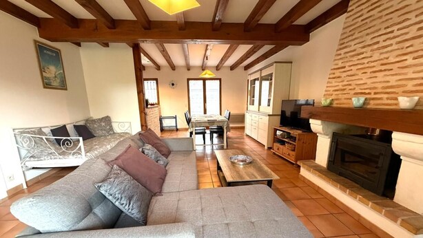 Una sala de estar con sofá, mesa de comedor y chimenea.