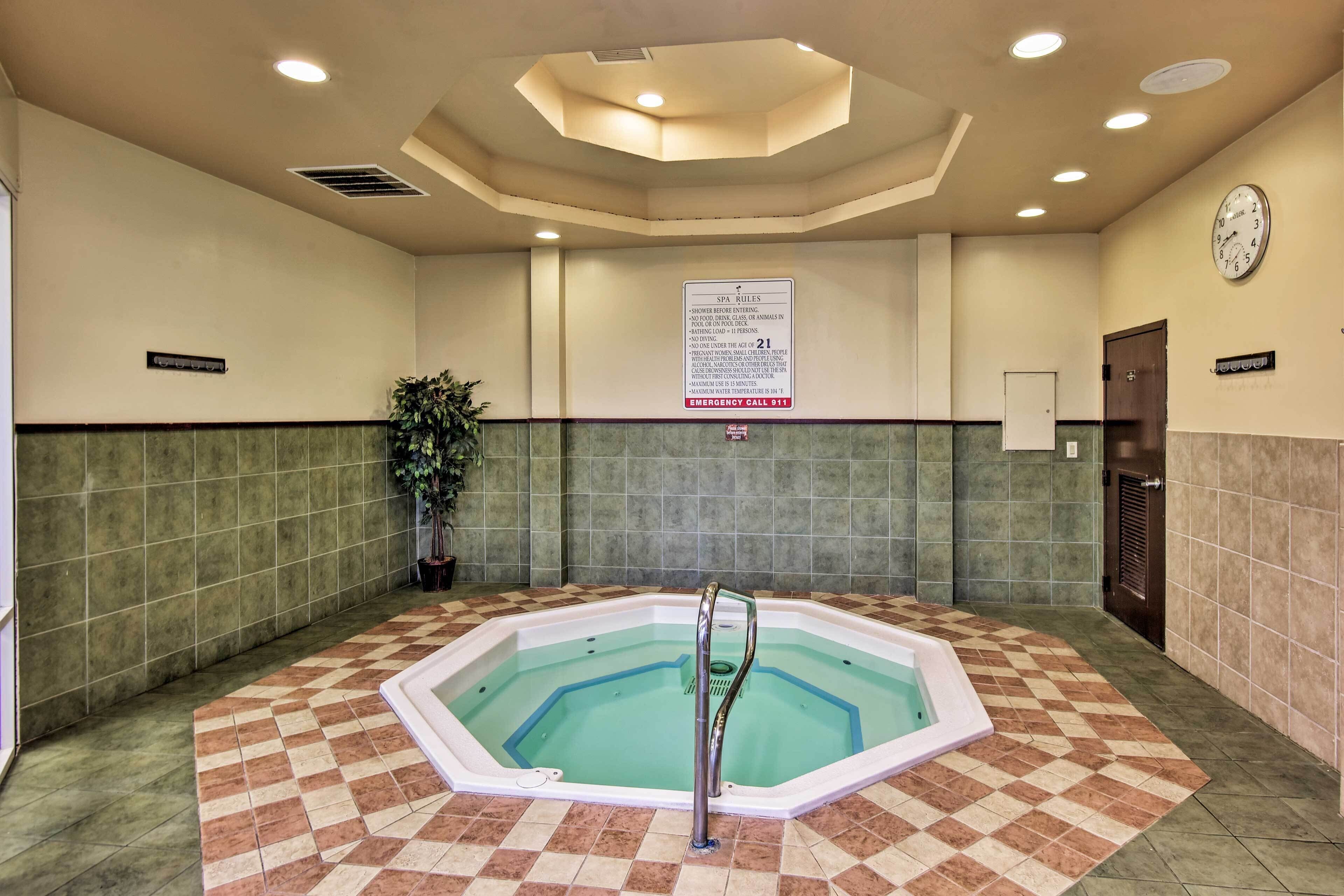 Ein Wellnessbereich mit Whirlpool, einer Uhr und einem Schild mit den Spa-Regeln.