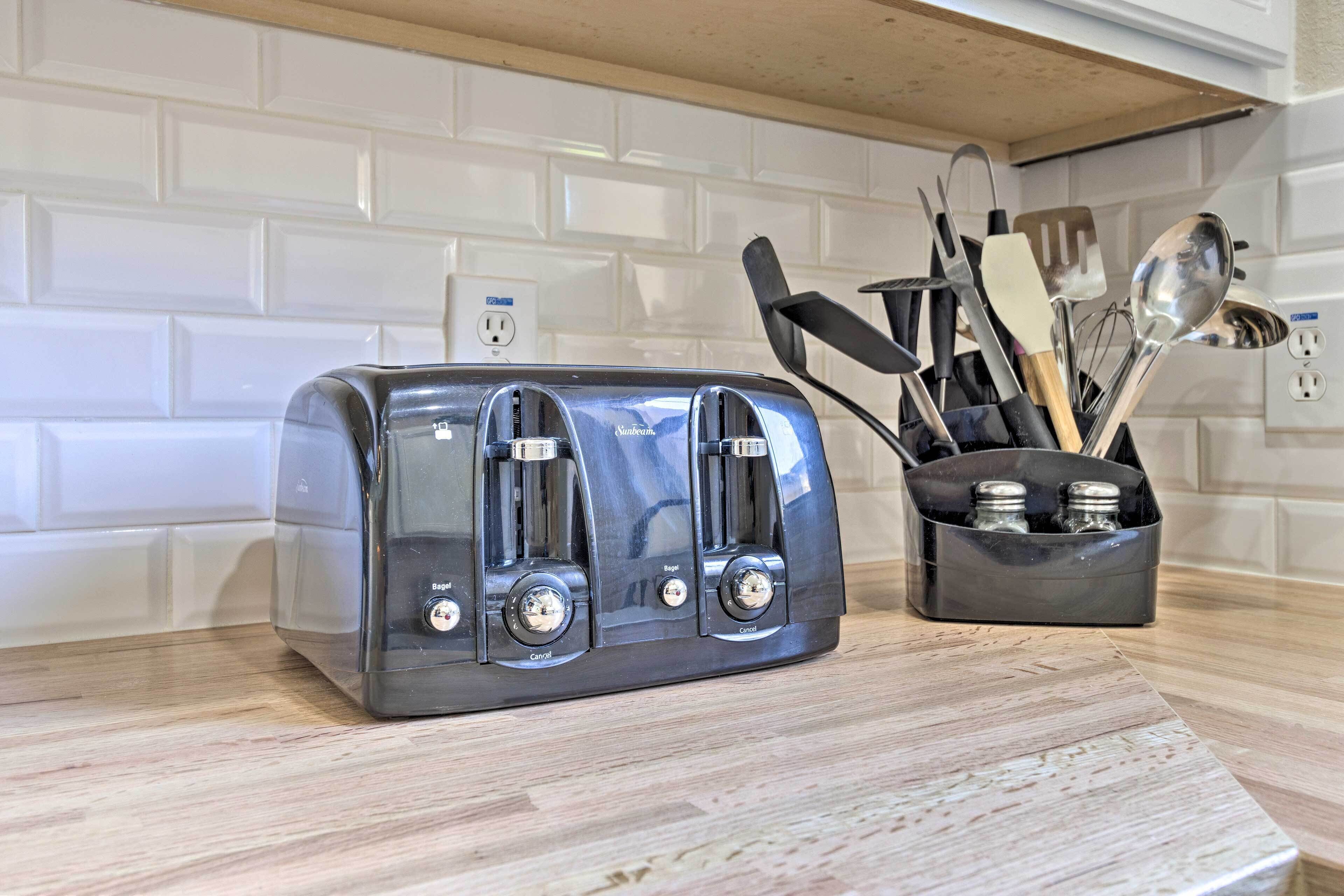 A kitchen with a toaster on the counter, a knife block with utensils, and a white tiled backsplash.