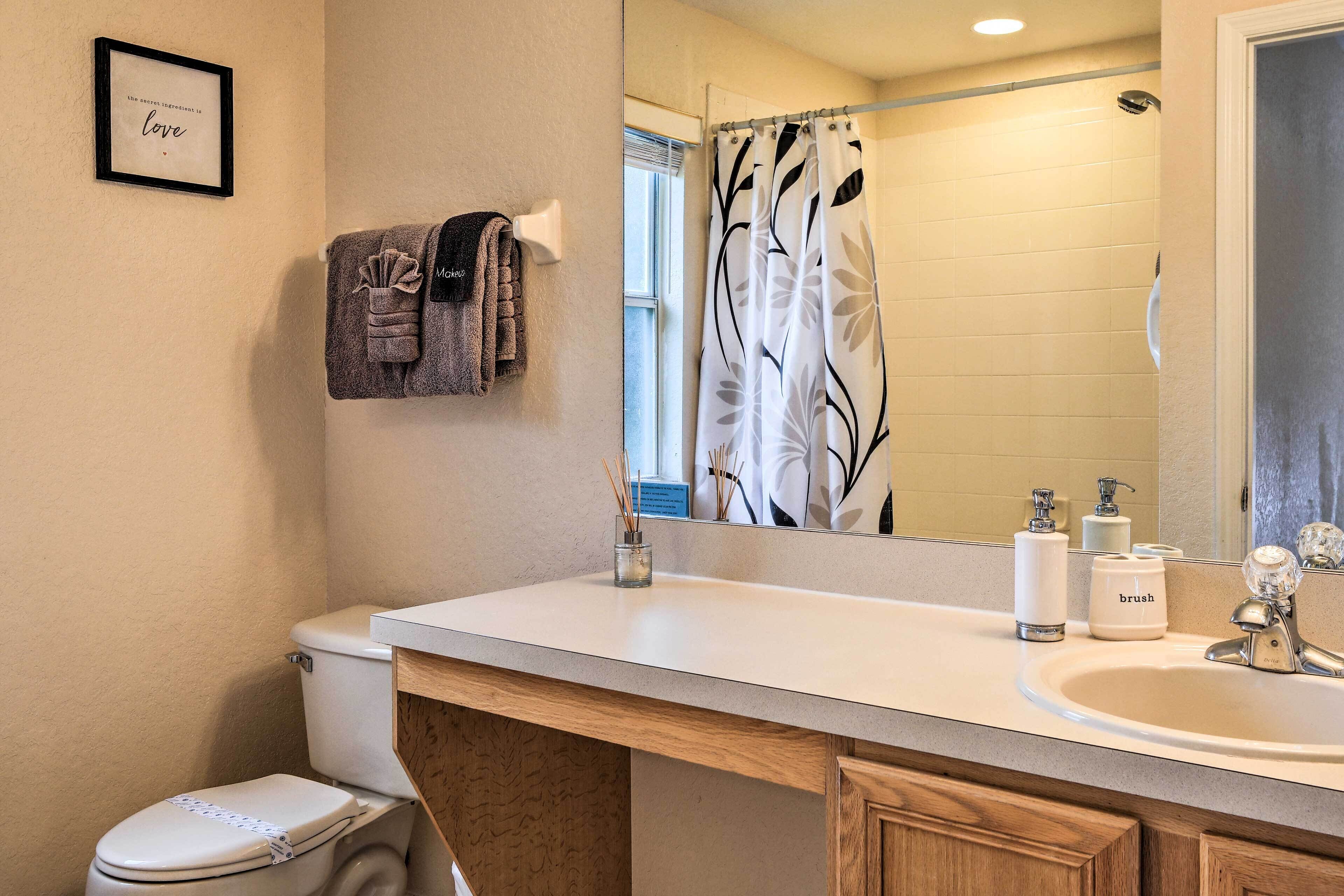 A bathroom with a toilet, sink, and shower curtain.