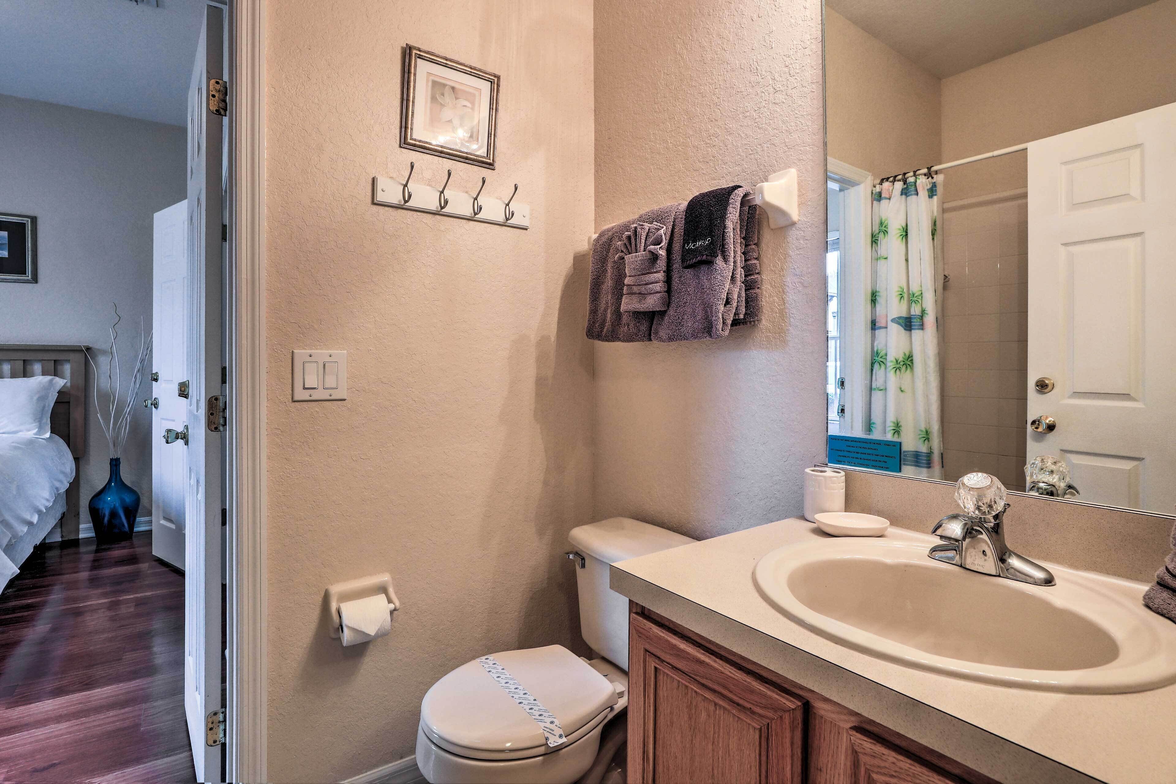 A bathroom with a toilet, sink, and shower curtain.