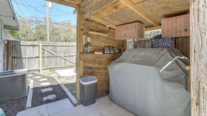 A covered outdoor area with a barbecue grill, a trash can, and a wooden fence. - Pet-friendly Largo Escape w/ Fire Pit! (Largo)