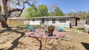A house with a patio area featuring two chairs and a table. - Pet-friendly Largo Escape w/ Fire Pit! (Largo)
