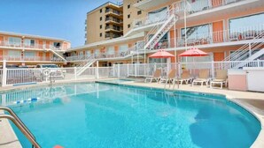 Et hotel med swimmingpool, flere balkoner og udendørs siddeområder.