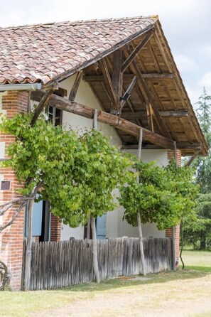 A rustic building with a tiled roof, wooden beams, and a brick facade.