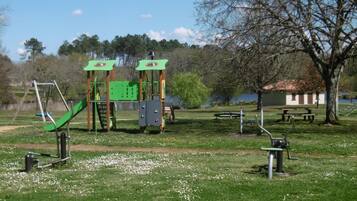 A playground with a slide, climbing structures, and swings.