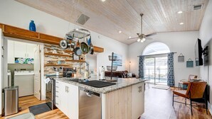 A spacious kitchen with a central island, wooden cabinets, and a large window providing natural light. - Kissimmee Retreat w/ Private Basketball Court! (Kissimmee)