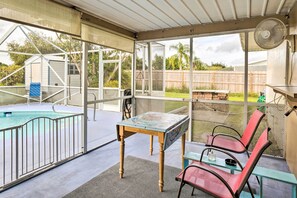 Un espace extérieur abrité comprenant une piscine, une table et des chaises.