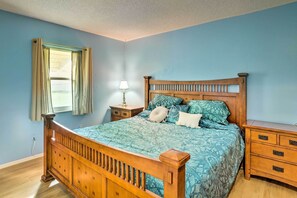 Une chambre à coucher avec un lit en bois, une table de chevet et une commode.