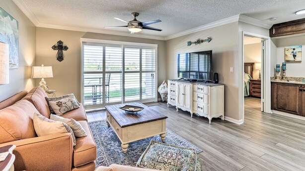 A spacious living room with a sofa, coffee table, and a television.