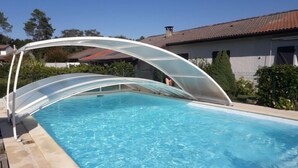 Una piscina con una estructura de techo blanca y curvada.