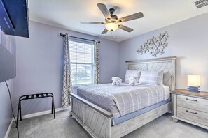 A bedroom with a bed, nightstand, ceiling fan, and a window with curtains. - Riverview Abode w/ Large Backyard & Fire Pit! (Riverview)