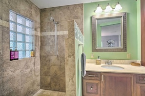 A bathroom with a shower, a sink, and a vanity with cabinets. - Vero Beach Oasis < 7 Mi to South Beach Park! (Vero Beach)