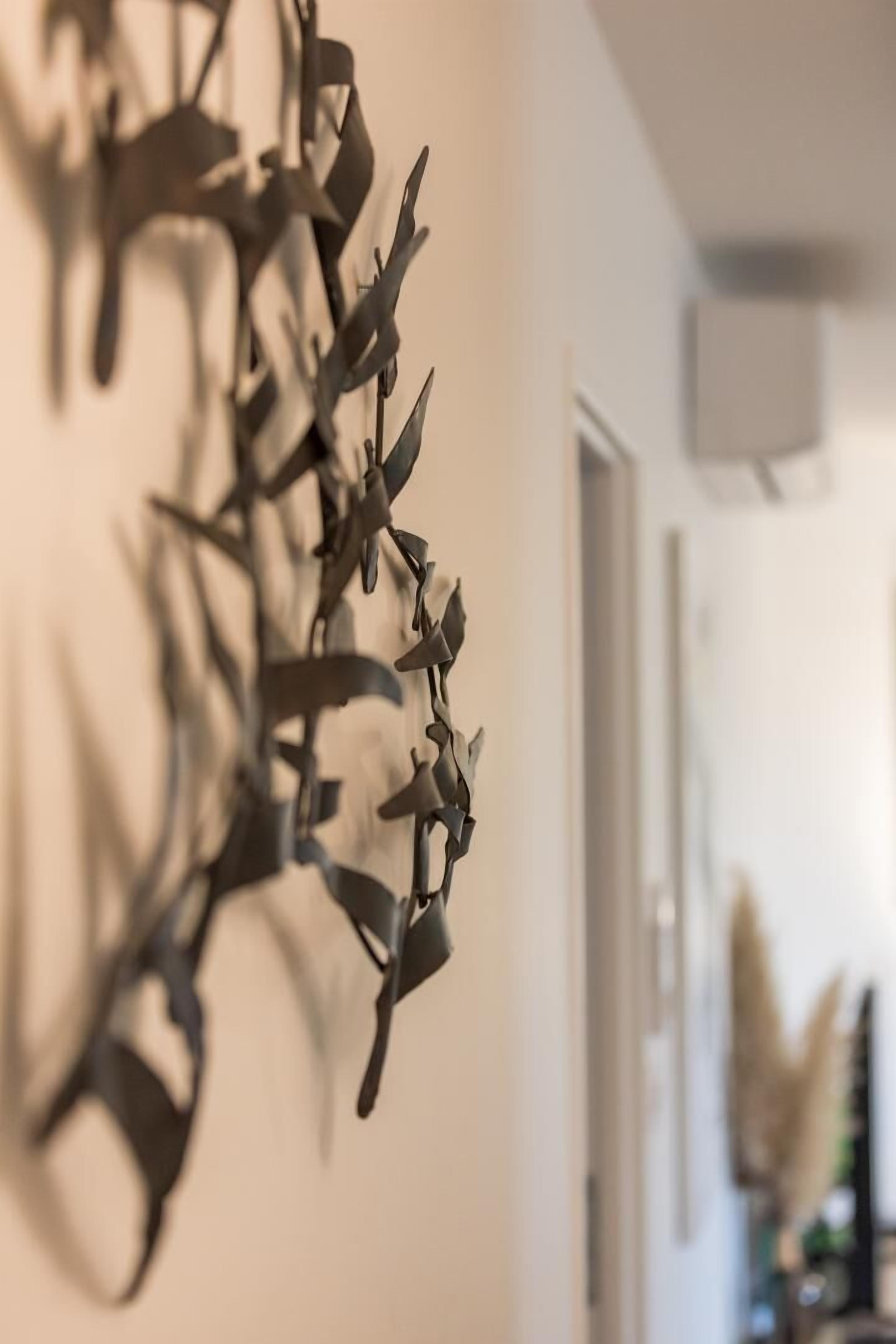 A modern interior with a metallic abstract wall art piece.