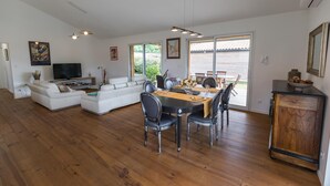 Amplia sala de estar con mesa de comedor, sofá y televisor.