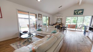 Una sala de estar amplia con un sofá grande, una mesa de centro y un comedor con sillas y una mesa.