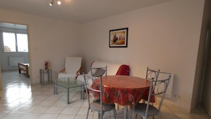A dining area with a round table and chairs, a bench, and a sofa.
