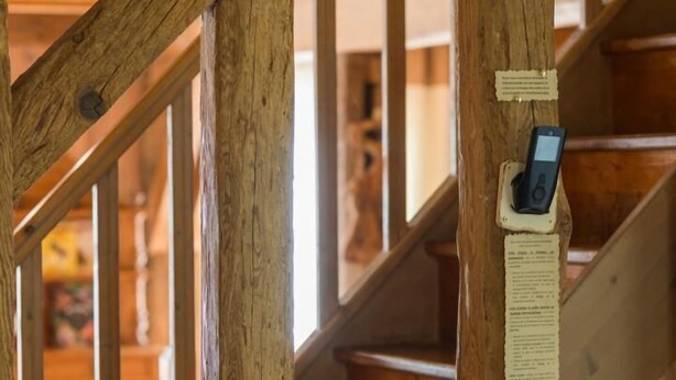 A wooden staircase with a security device attached to a post. - Vieux Chêne - Vert - Gîte (VERT)