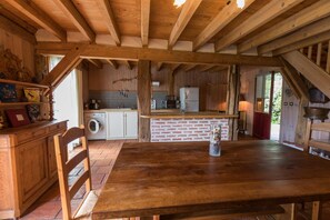 Una cucina rustica con travi in legno, un'isola in mattoni e un tavolo da pranzo.