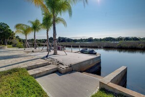 A waterfront park with concrete steps leading to a dock, palm trees, and a calm body of water. - Luxe Spring Hill Home w/ Patio & Dock! (Spring Hill)