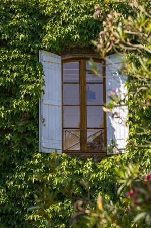 A room with a large window, surrounded by dense foliage. - La Tour du Manoir - Betbezer-d'armagnac (BETBEZER-D'ARMAGNAC)