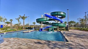 A water park with a multi-level water slide structure, a swimming pool, and a tiled deck area. - Resort Getaway w/ Patio: 6 Mi to Disney Parks! (Kissimmee)