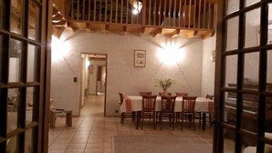 A dining area with a table set for four, wooden beams on the ceiling, and a framed picture on the wall.