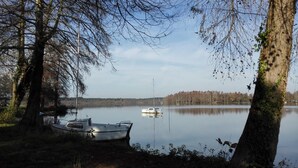 A calm lake with boats docked on the shore, surrounded by trees. - Les Palombières - SOUSTONS (SOUSTONS)