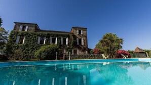 Un grand bâtiment avec une piscine devant.