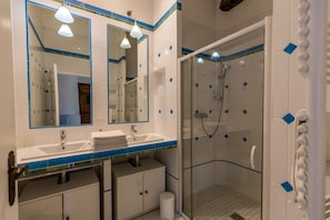 Un baño con dos lavabos, un espejo y una ducha.