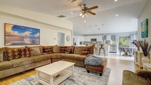 A spacious living room with a sectional sofa, a coffee table, and a ceiling fan. - Game Room & Deck: Spacious Home in St James City (Saint James City)