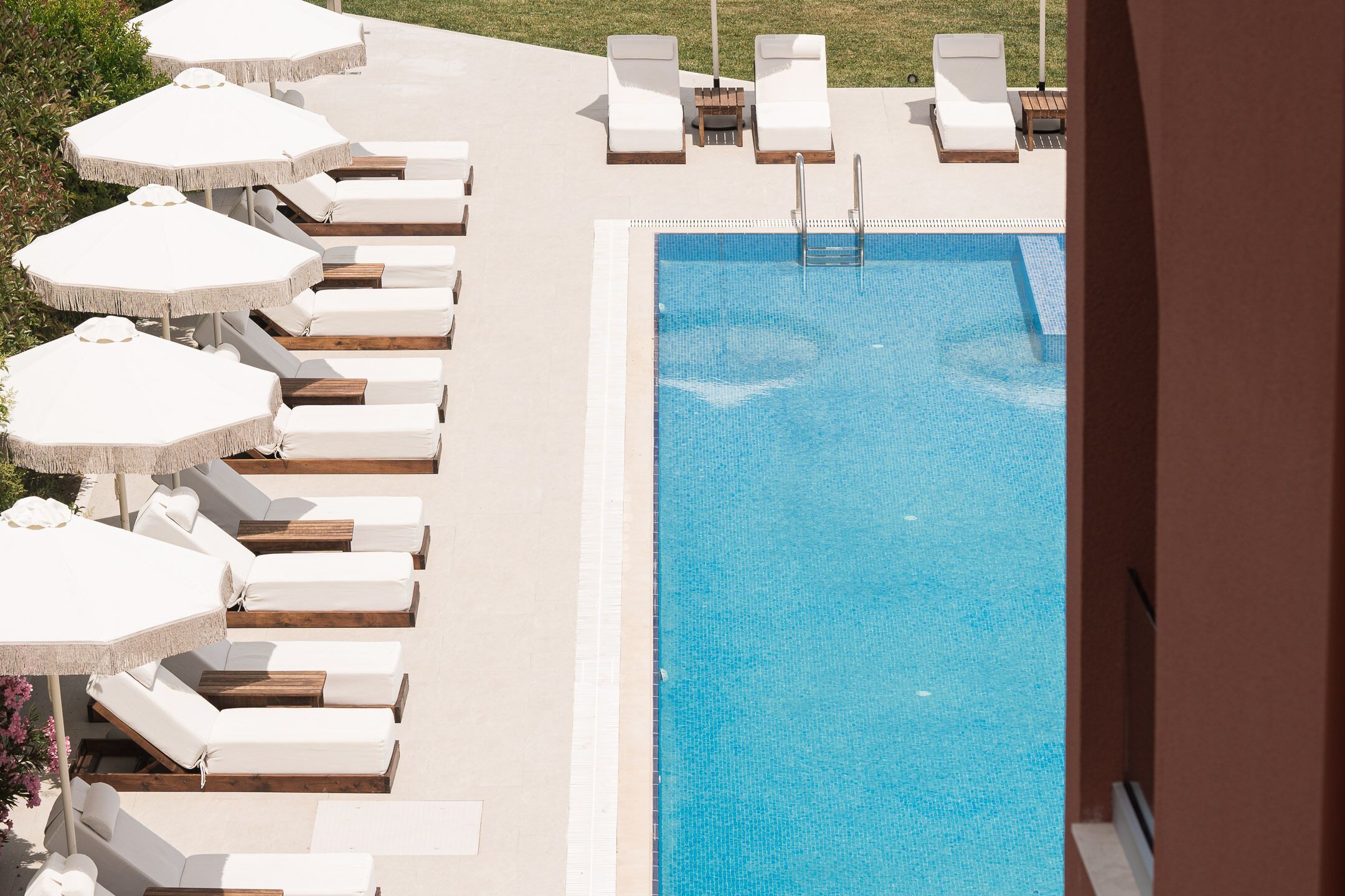 A pool area with lounge chairs and umbrellas.