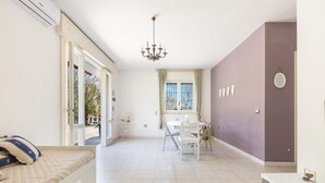 A bedroom with a bed, a desk, a chair, a chandelier, and a window with curtains. - 3335 Podere Li Noci by Barbarhouse (Melendugno)