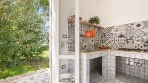 A kitchen with patterned tiles, a gas stove, and a bowl on the counter. - 3335 Podere Li Noci by Barbarhouse (Melendugno)