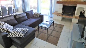 Una sala de estar con sofá, mesa de centro y chimenea.