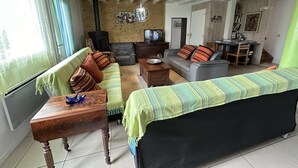 Een woonkamer met een bank, fauteuils, een salontafel en een open haard.