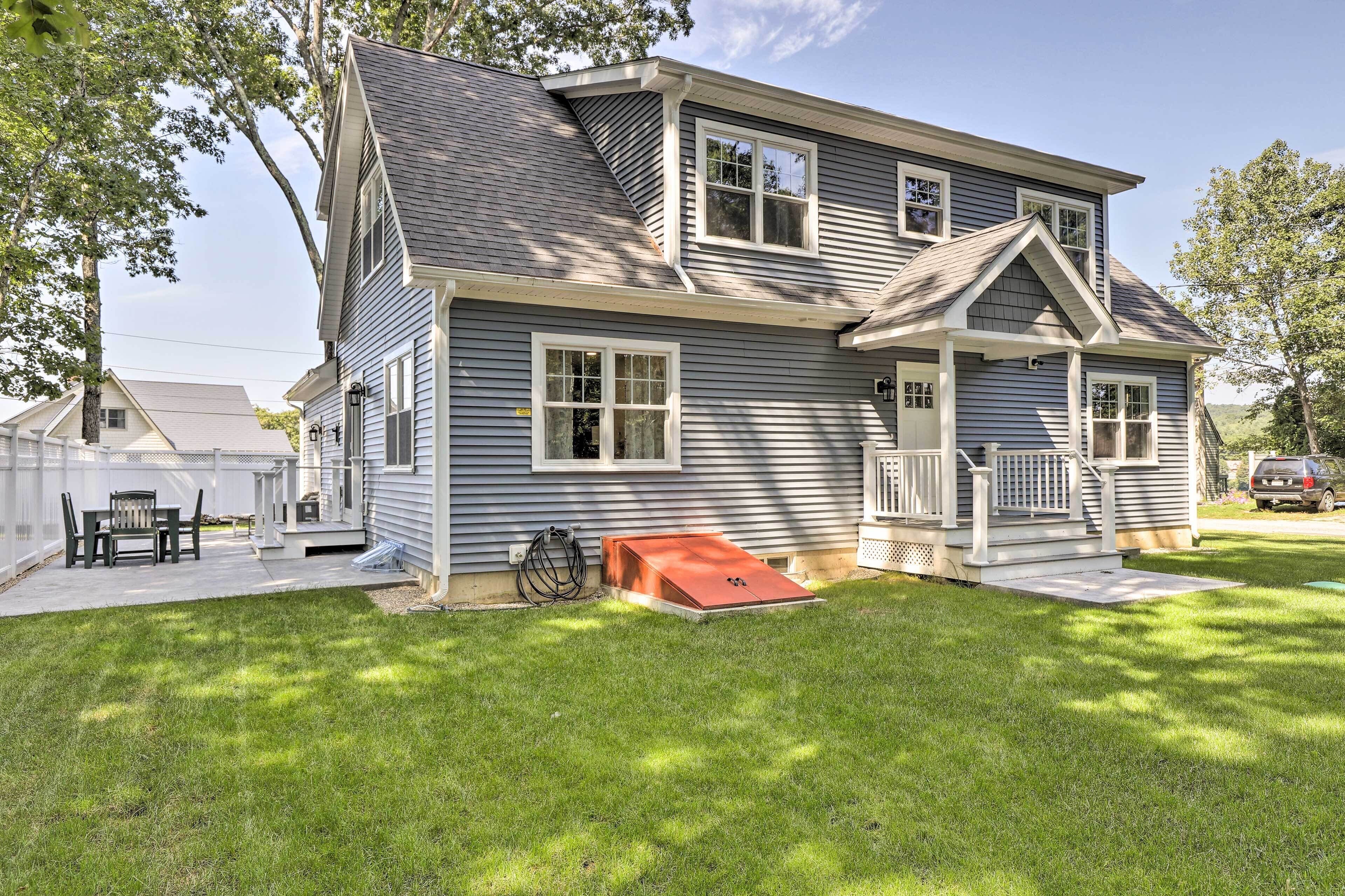 A two-story house with a covered porch, a small attached garage, and a well-maintained lawn.
