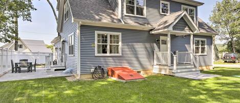 A two-story house with a covered porch, a small attached garage, and a well-maintained lawn.